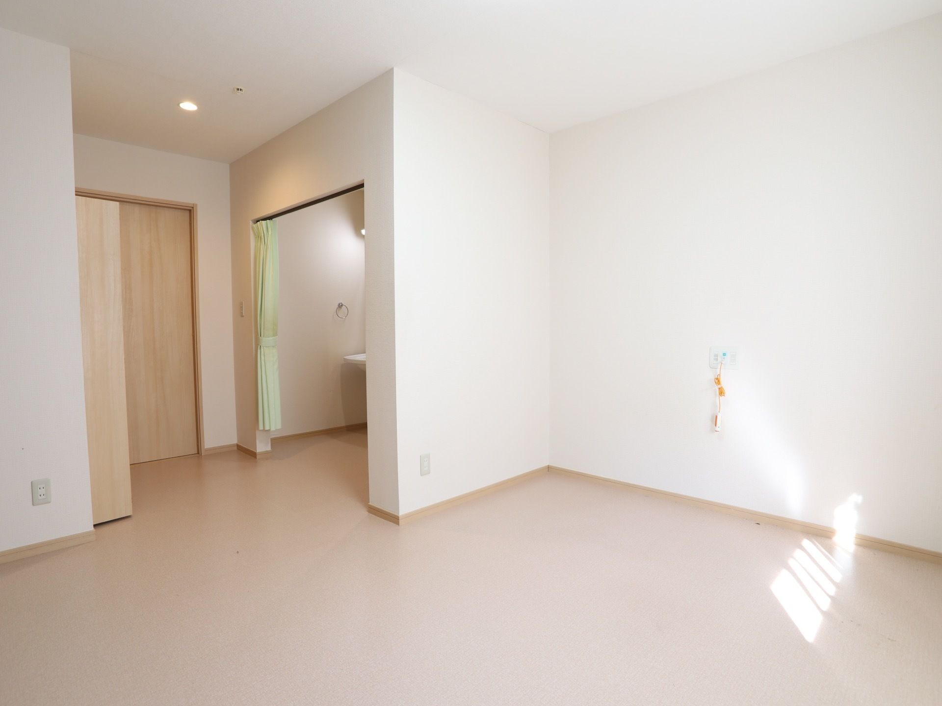 十分な広さのある居室である。洗面所があり、そばにはタオル掛けが備わっている。また、コンセントも数多くある。