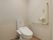 トイレの個室は白を基調とした清潔感がある空間に仕上がっている。便器の周囲にはスペースを広く取り、壁には手すりが取り付けられている。