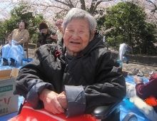 満開の桜の下でお花見を楽しむ女性入居者。