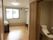 エアコンが付いたフローリングの部屋。手前にはスライド式のドアが設置されたトイレがある。