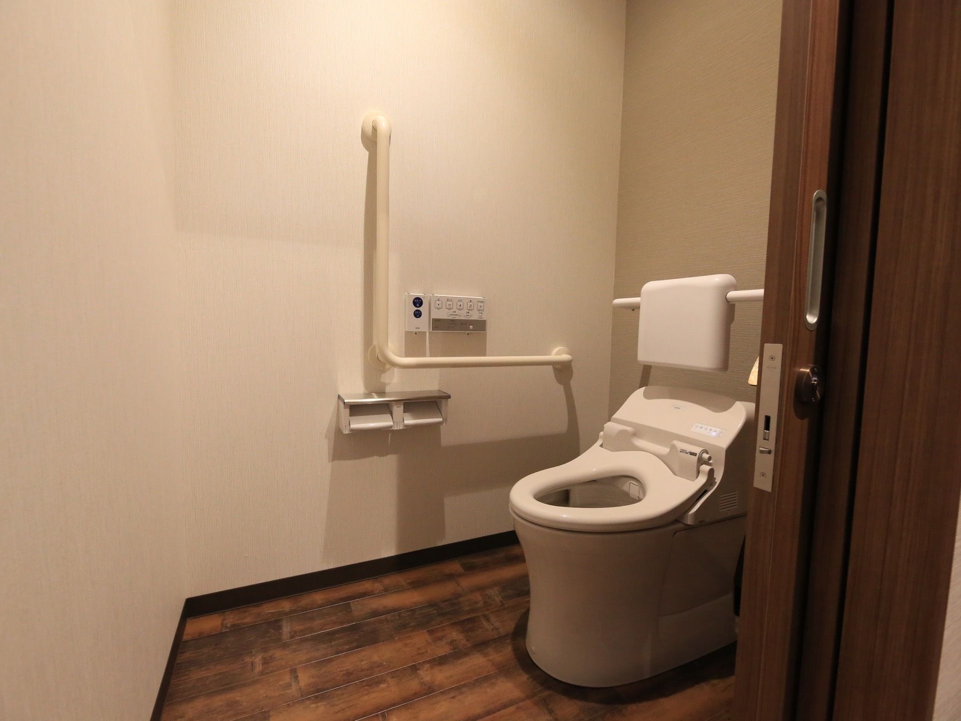 鍵をかけることができる引き戸の中のスペースにトイレが設置されている。便座の後ろには背もたれがついている。
