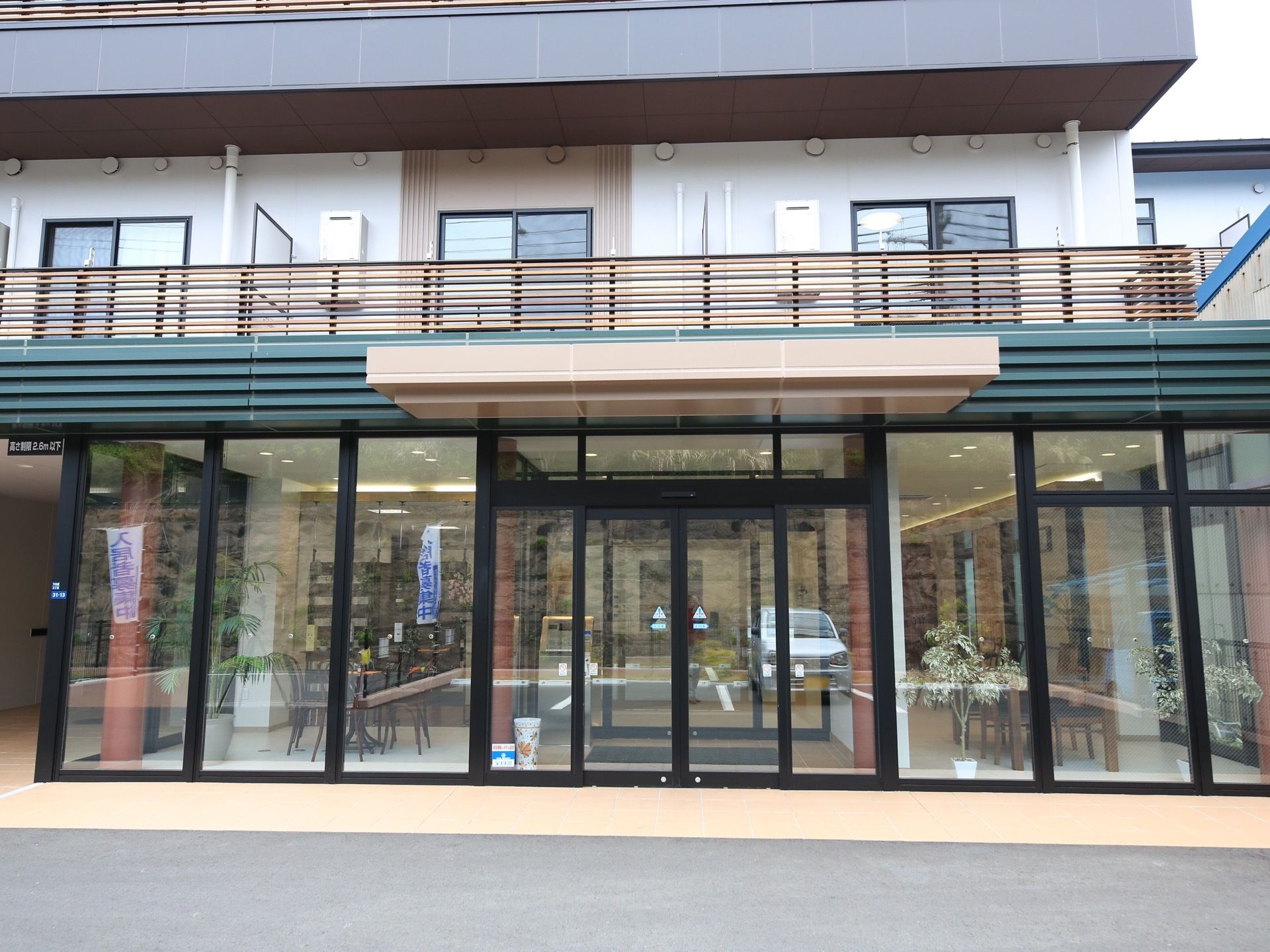 エントランス部分は全面ガラス張りにした、個性的で開放的なデザイン。日の光をより建物内に取り込めるようになっている。