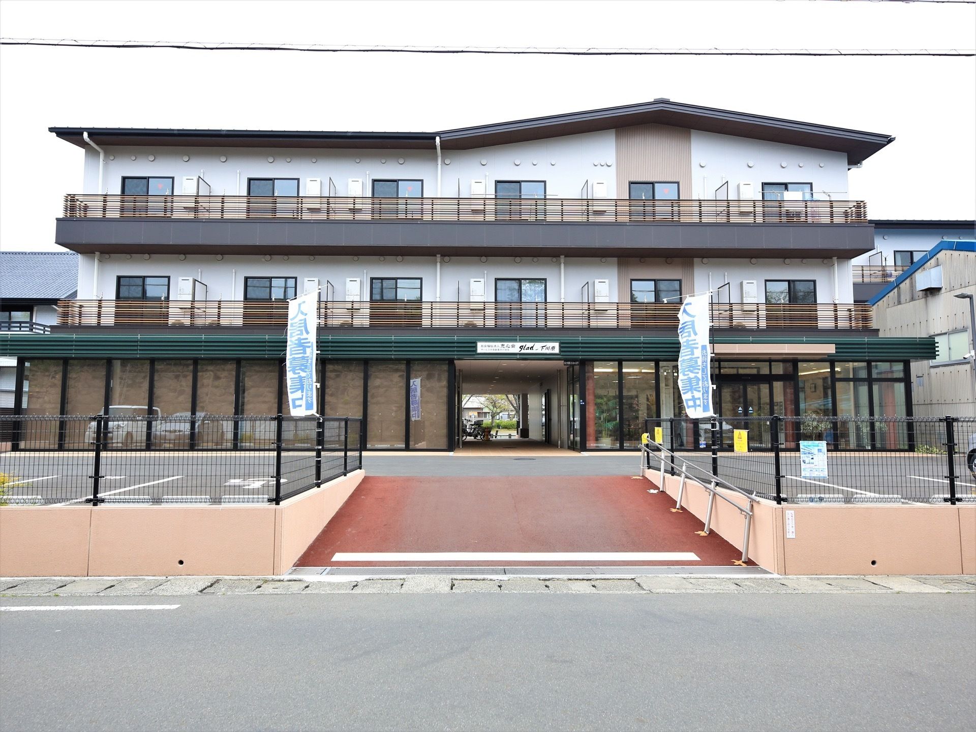 施設は３階建てである。個性的でモダンなデザインの外観。広々とした敷地を有し、余裕をもって建てられている。