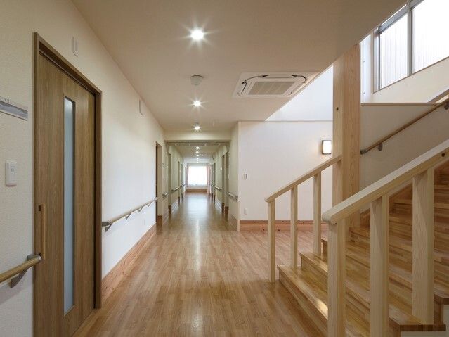 水を差し出す女性スタッフと薬を飲む高齢女性