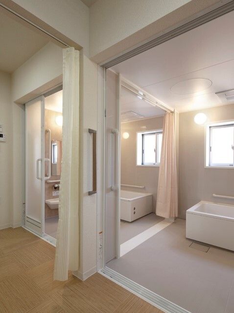 車椅子に乗った高齢女性と介助をする女性ヘルパー
