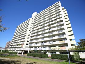14階建ての施設が建っており、２階のベランダに施設名称が記された横断幕が取り付けてある。建物の周囲に木々や芝生が茂っている。