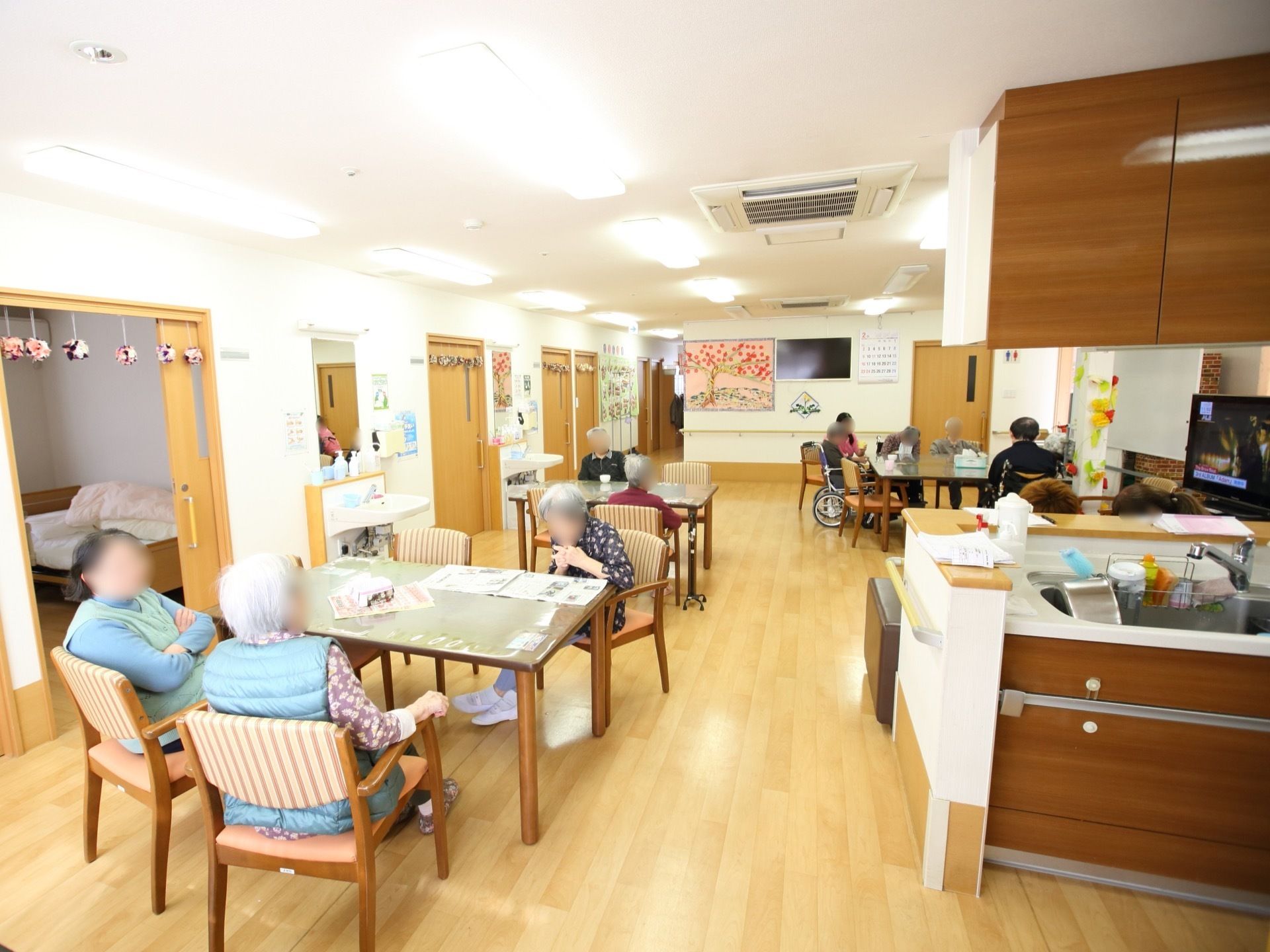 デイルームはフロアの中央に位置していて、居室からも近く便利な間取りである。天井が高く広々として、居心地の良い雰囲気。
