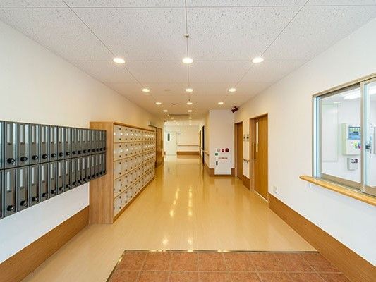 エントランス右手には受付、左手には入居者の郵便受けと靴箱が並んでいる。