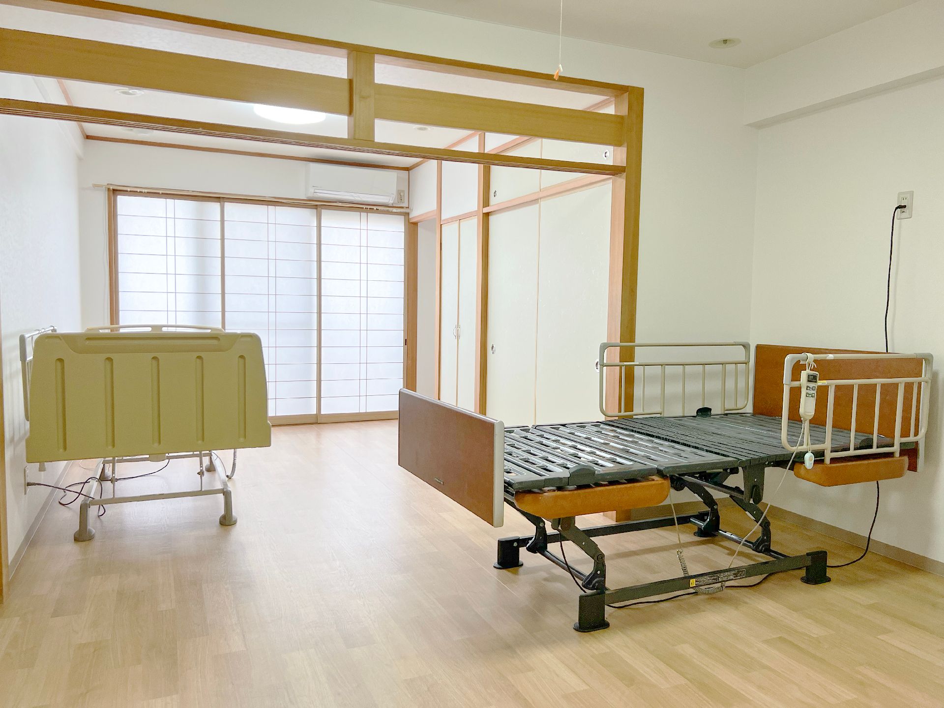 障子の扉があるベランダに面した和室タイプの居室には座卓、座椅子が置かれ、ゆったりとリラックスできる空間。
