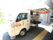 軽トラックの移動スーパーが施設を訪問している。荷台の壁が上がられていて、黒色のかごが並べられている。