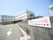 道路からの導入路に建っているブロック塀に横長の看板が設置されている。提供サービスと施設名称が表示されている。