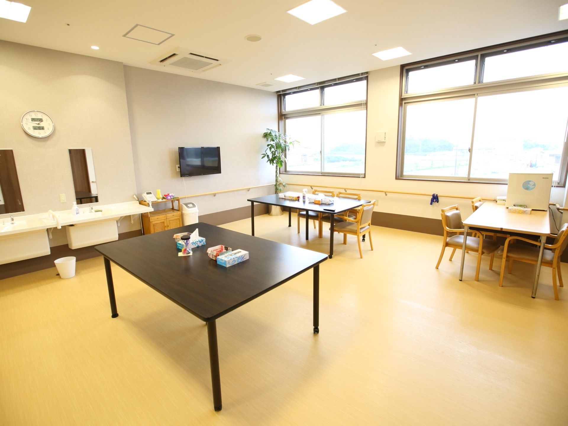 食堂の壁には液晶テレビがかかっている。洗面スペースが併設されており、食前食後の手洗いや歯磨きを気軽に行える。