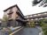 施設は３階建てで、外壁が茶色や黒で塗られている。施設周囲はたくさんの植物が植えられ、きれいに剪定されている。
