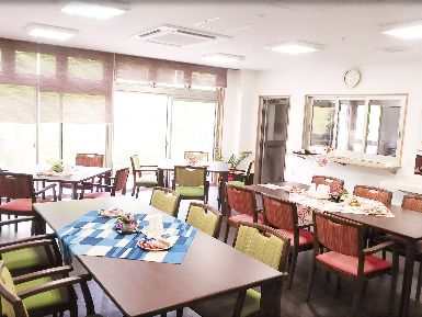 サイズの異なるダイイングテーブルが複数置かれた食堂。大きな窓が付き、明るい食堂。