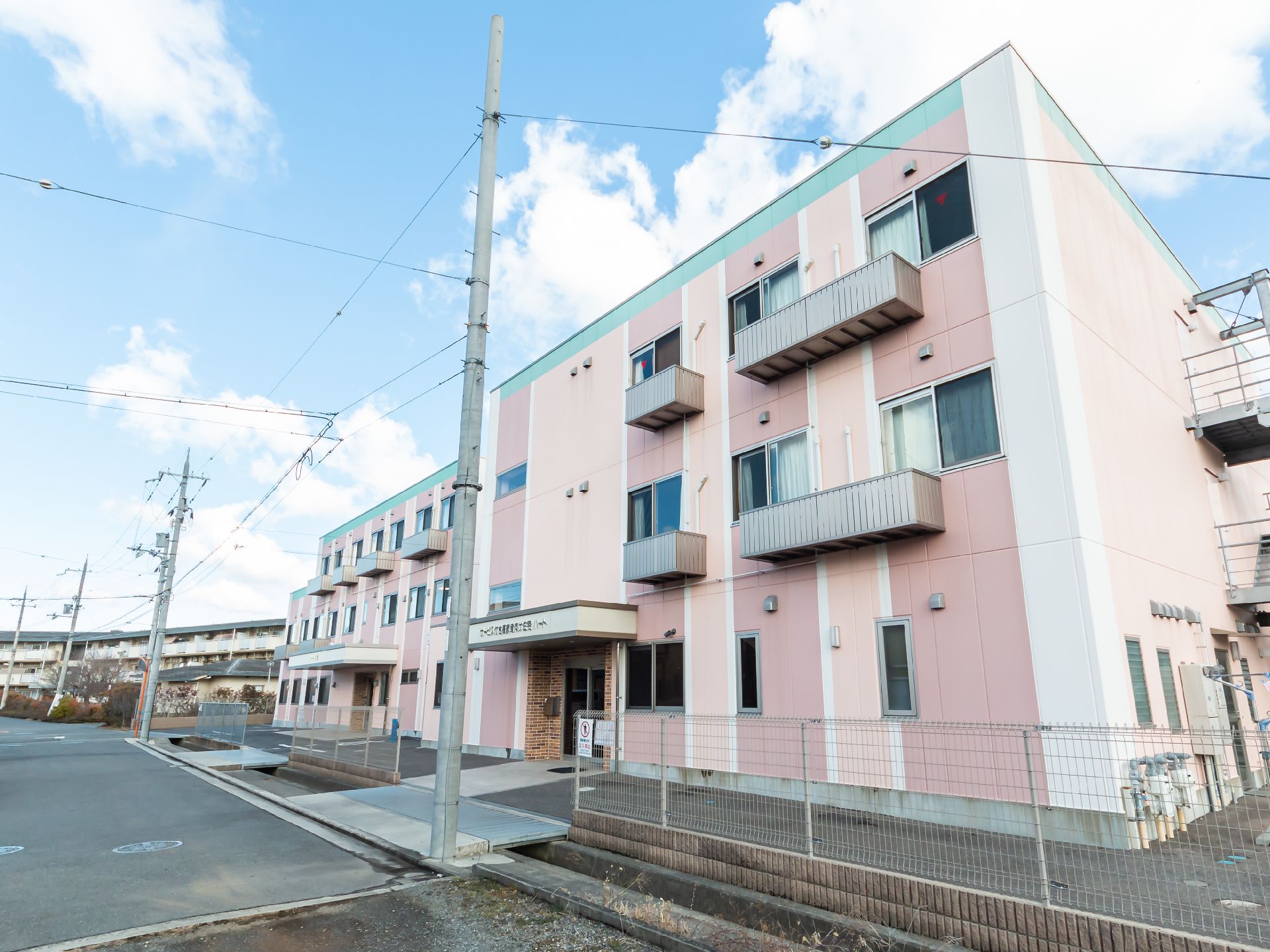 駐車場の出入り口から見た、斜め前から見た施設全体の外観