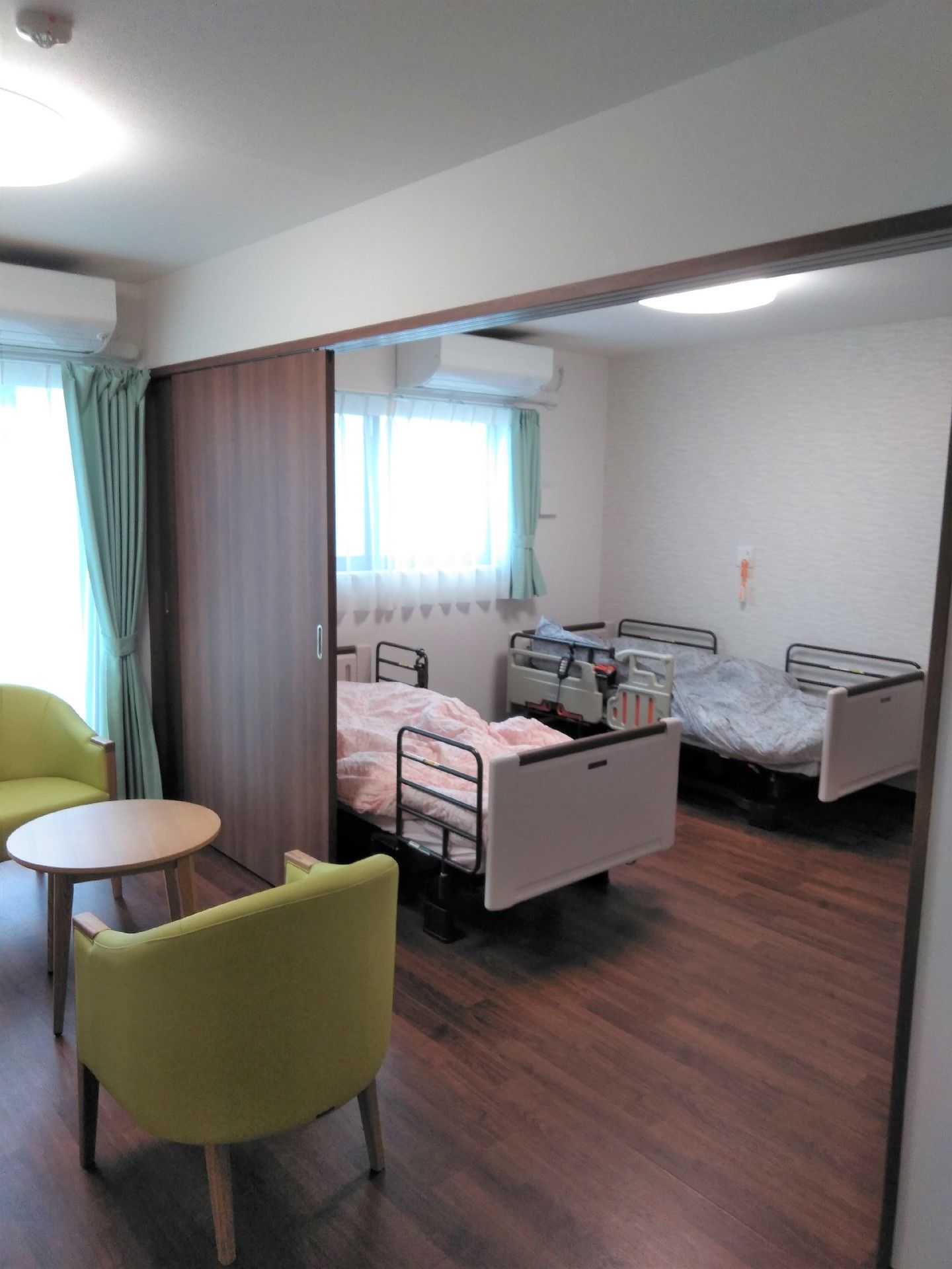 ベッドの2つ並んだ二人部屋。窓の外から明かりが漏れている。