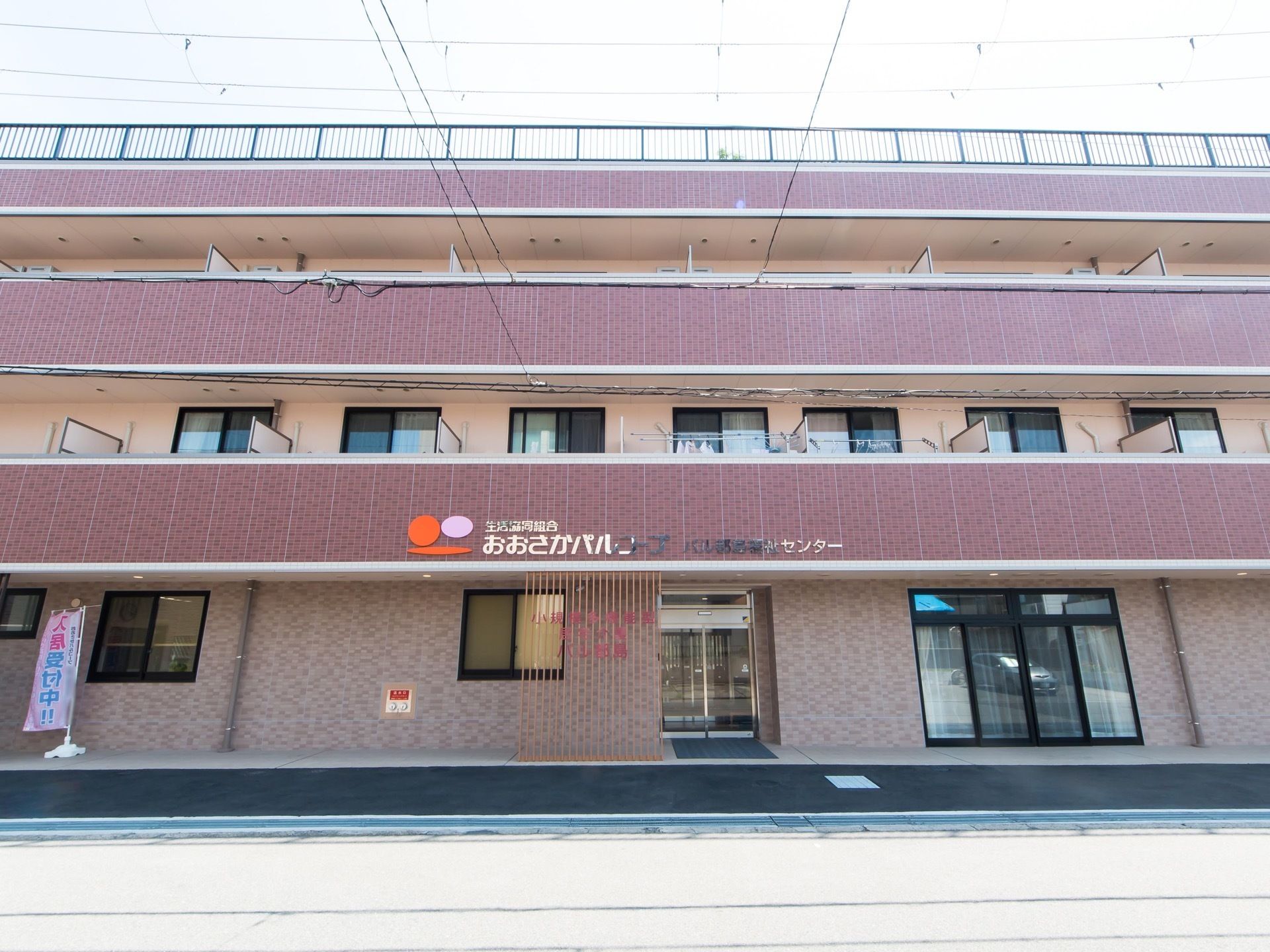 周囲の景観に馴染むよう落ち着いたブラウンの壁になっている。玄関は自動ドアになっており、地面も綺麗に整備されている。