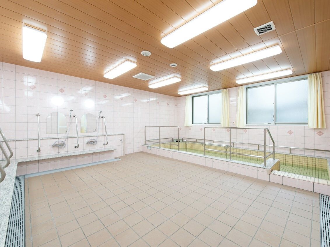 手すりが付いた大きな浴槽にはたっぷりのお湯が張られている。向かい側には手すり付きのシャワースペースもある。