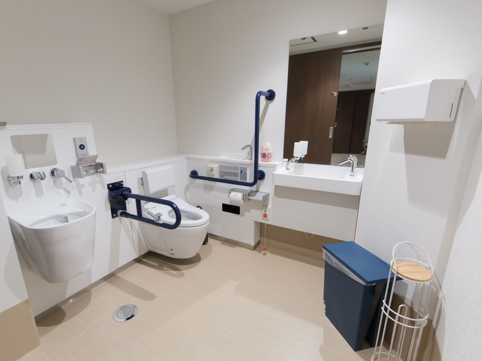 車椅子対応の広々としたトイレがある。便座の周りには手すりが備え付けられ、隣にはオストメイト用の設備も付いている。