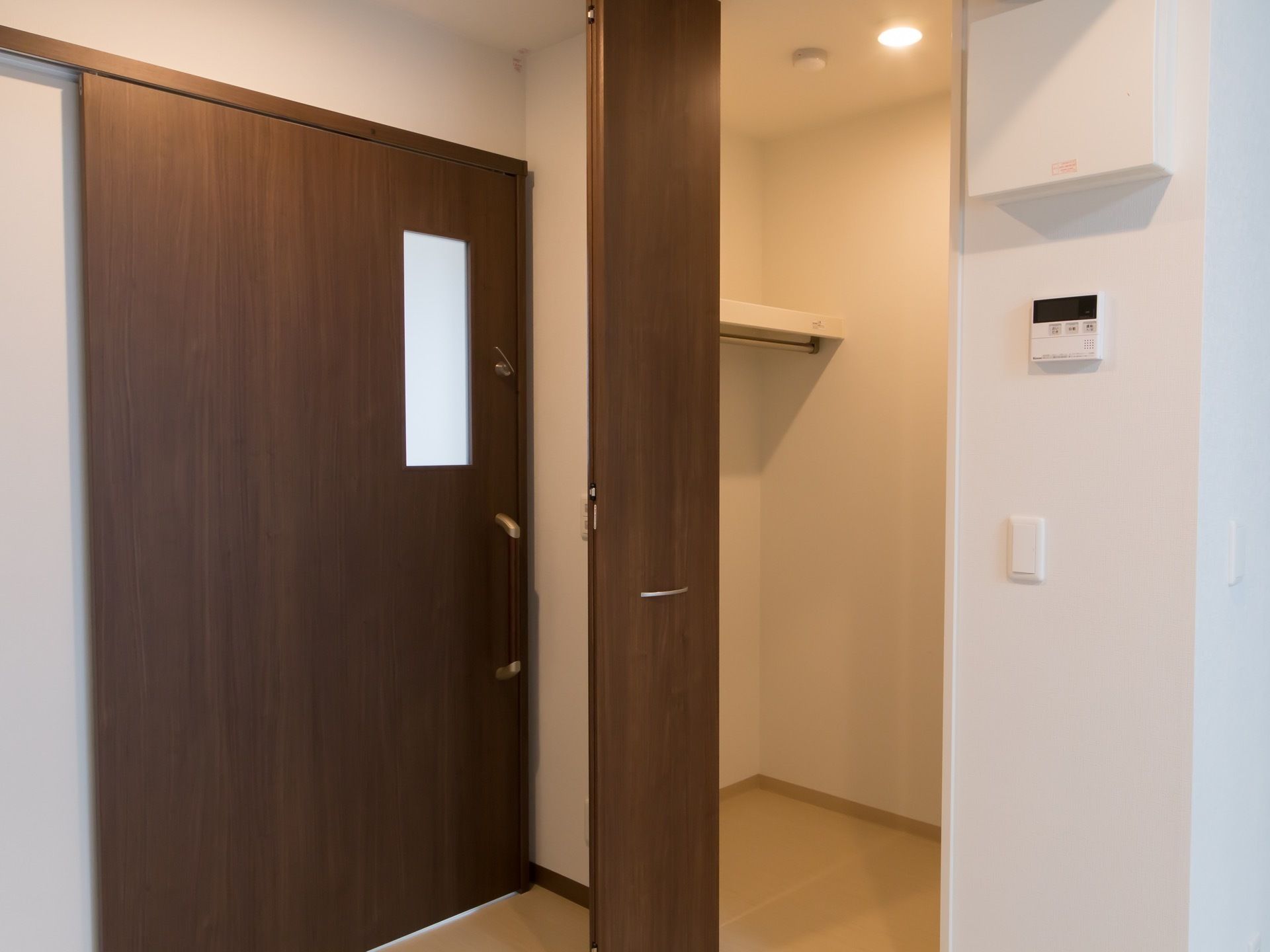 木目調の大きな引き戸で仕切られた居室がある。入り口を入るとすぐ左手に、照明の付いたウォークインクローゼットがある。