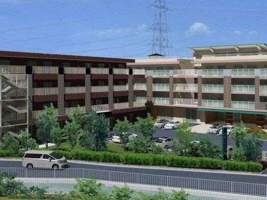 エル字型のブラウン系の3階建ての建物の敷地内には広い駐車場があり、日当たり良好。