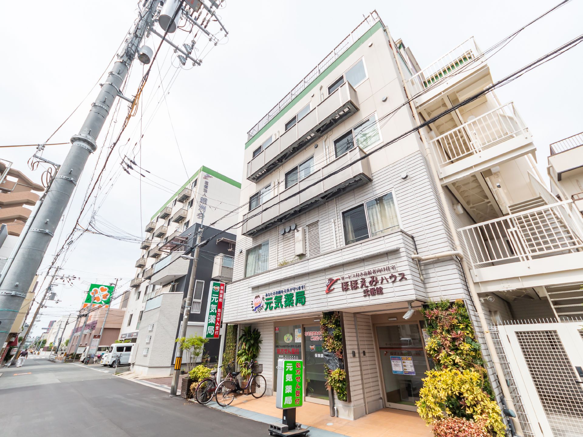 地上４階建ての全体が白色をした外観の高齢者向け住宅