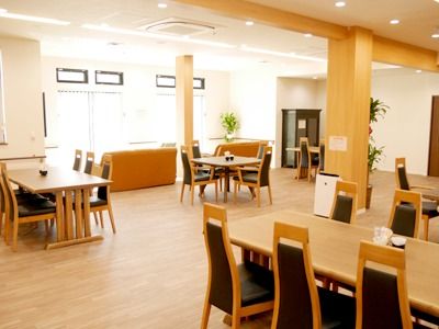 木製のテーブルが複数設置された広い食堂にはソファスペースもある。