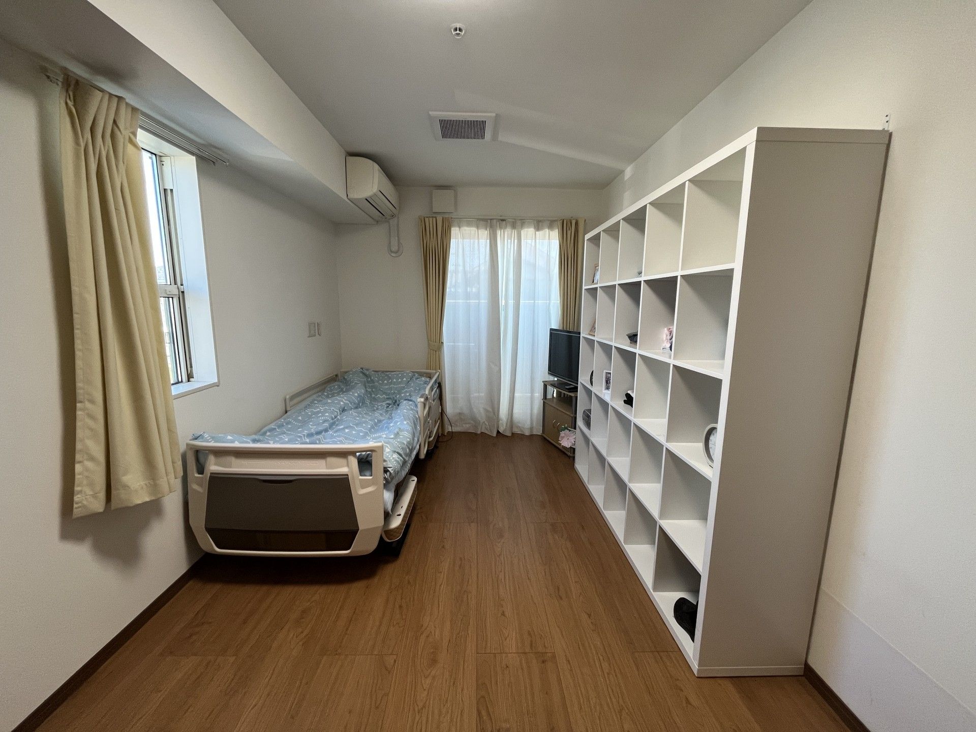 車いすに乗った女性を押す家族の男性とそこに寄り添う介護スタッフの様子