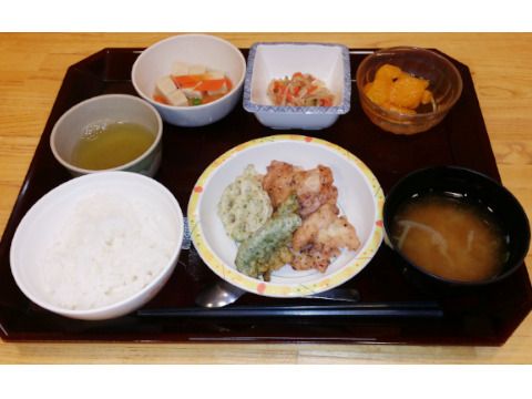 スタッフと高齢者が話している様子。カルテのようなものを書いている場面