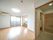 広々とした部屋の右隣に、ベッドが置かれている部屋があり、どちらの部屋にも掃き出しの窓がある。右側に浴室とトイレが見える。