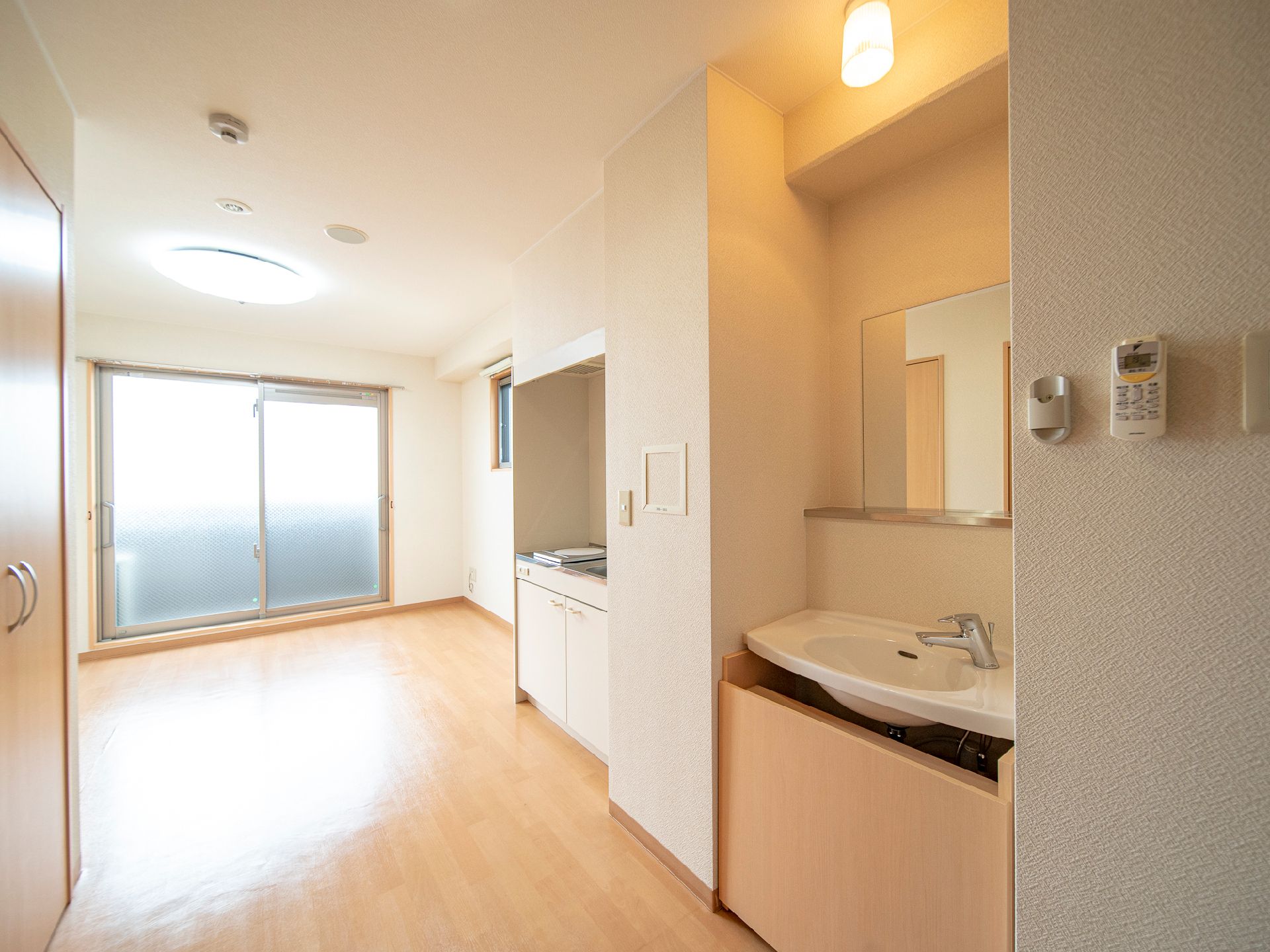 キッチンがあるワンルームタイプの部屋の様子。ベッドやいすなどが並べてある部屋