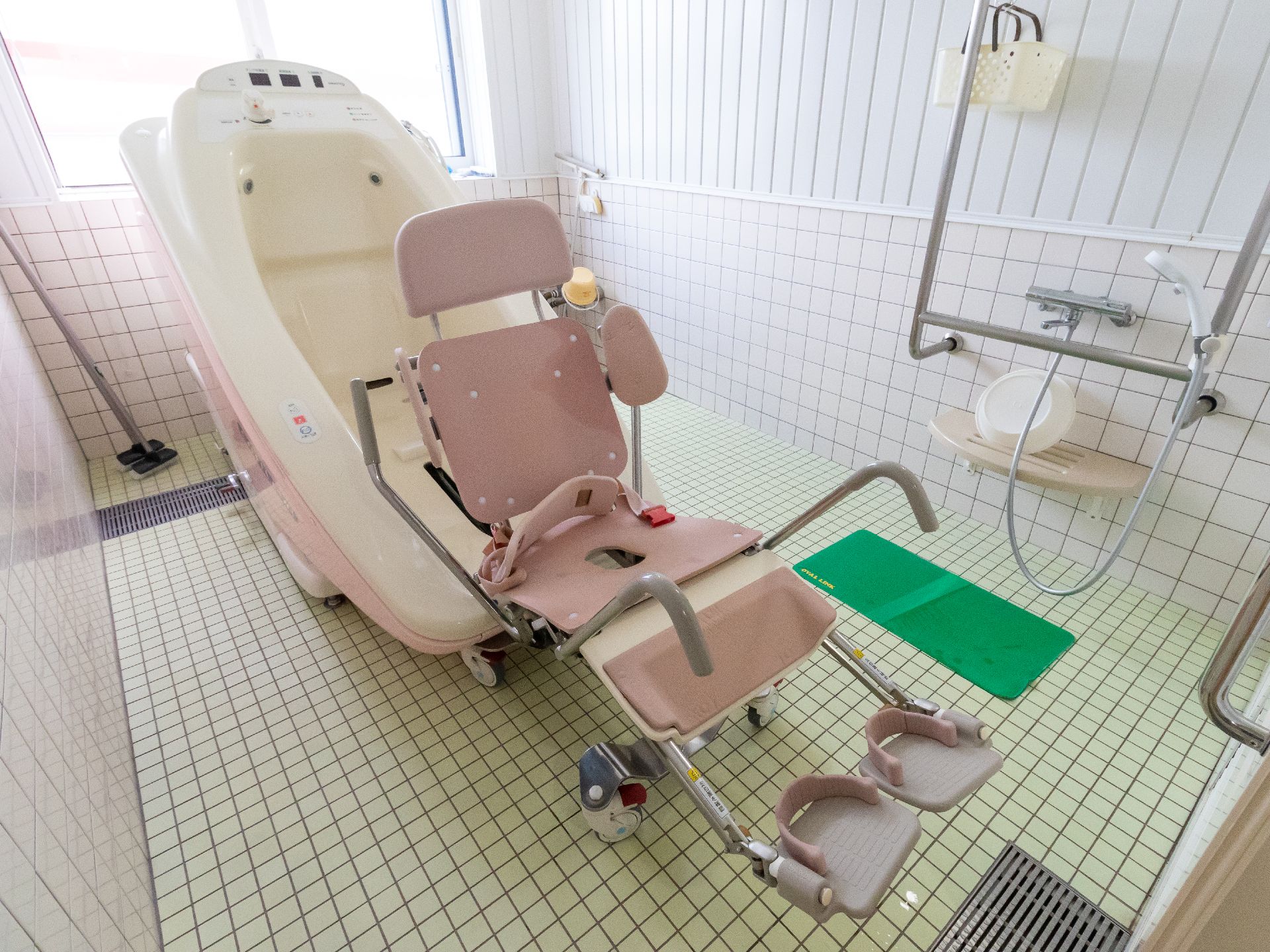 車椅子型のストレッチャー付きの特殊入浴装置が設置されている浴室