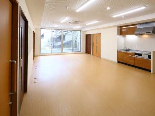 開放的な広々とした建物の内部。キッチンスペースと手前にドアが写っている様子