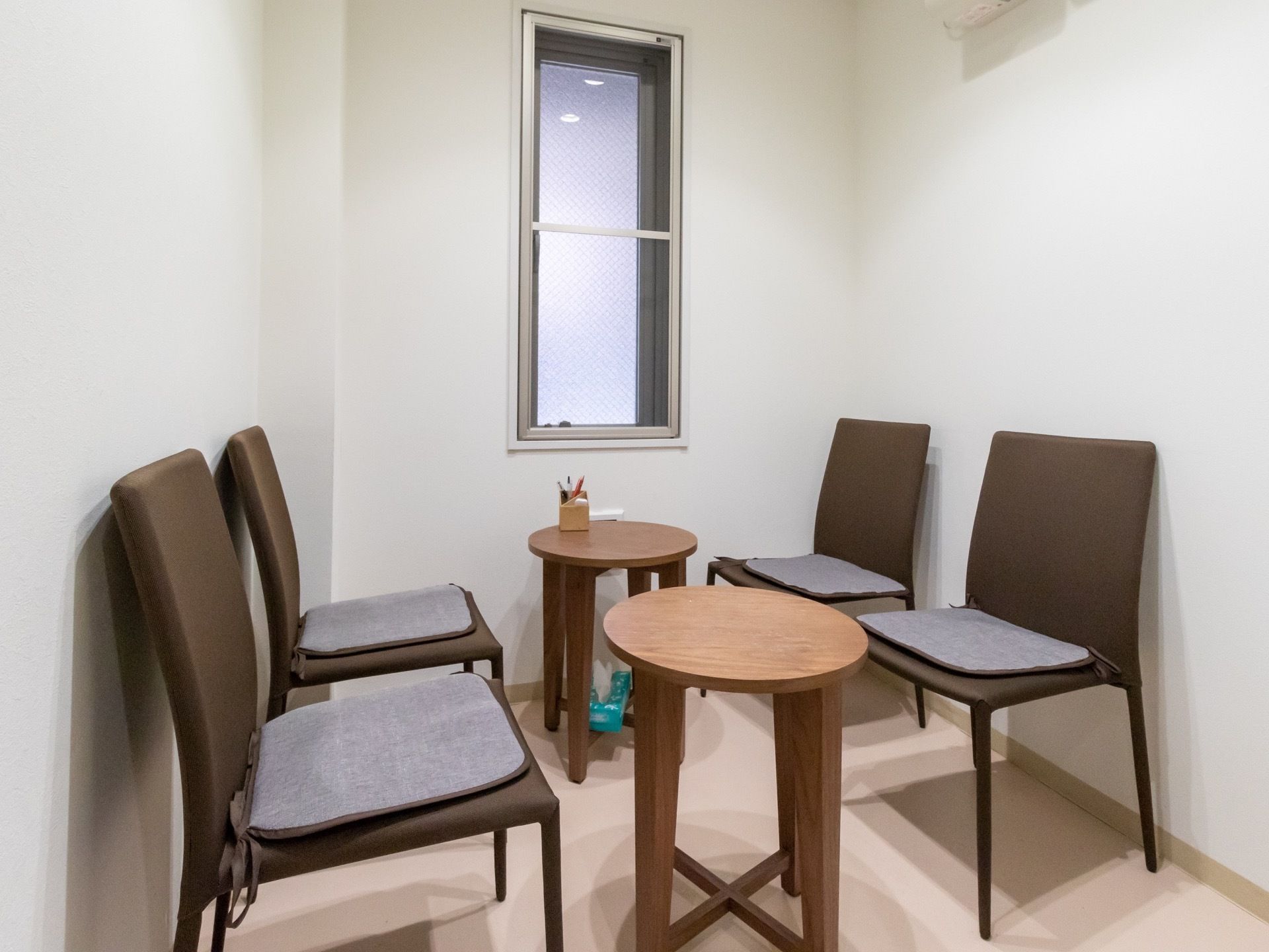 小さな丸テーブルと椅子がセットされた小部屋がある。採光用の細長い窓があり、テーブルの上には筆記用具が置かれている。