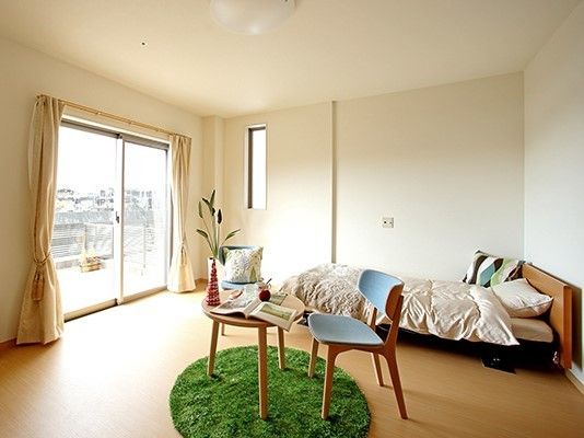 一人用のベッドと小さなテレビがある部屋の様子。ミニテーブルと椅子がある部屋