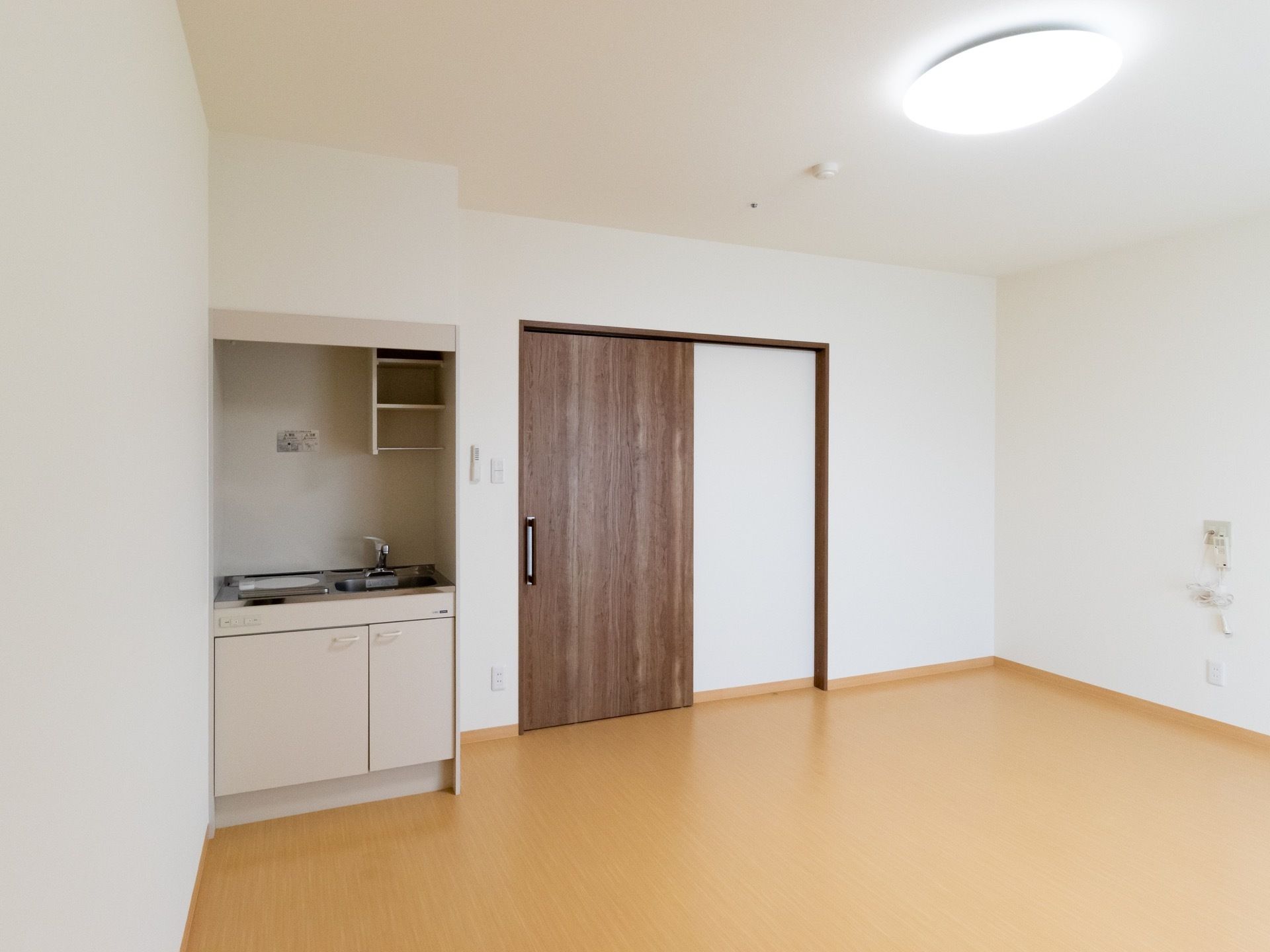 白を基調とした明るい居室には、コンパクトなキッチンが備わっている。お湯を沸かしてティータイムが楽しめる。