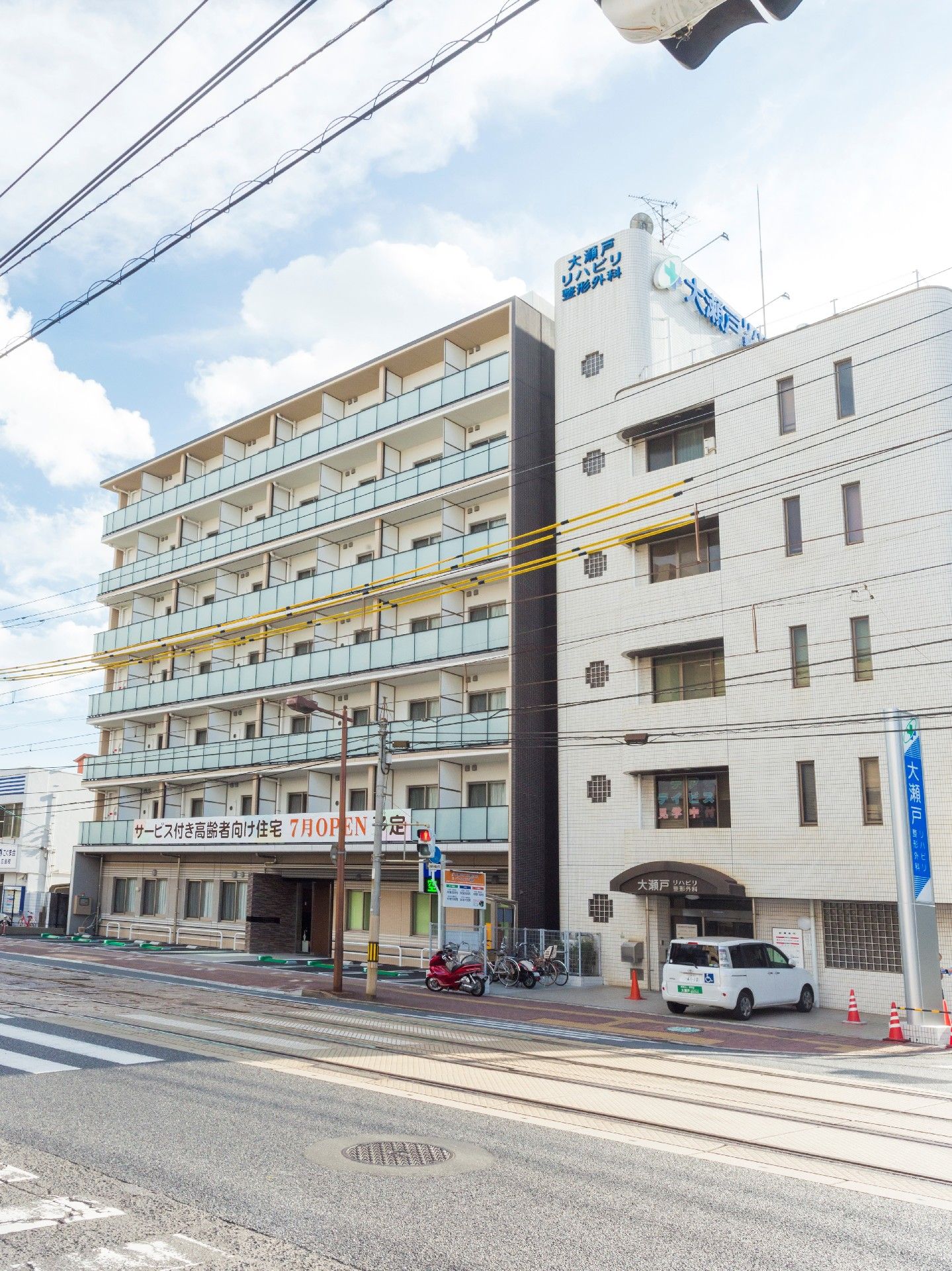建物がつらなる街並みを写した写真。白い壁のビルと優しい色合いの建物が２つ並んでいる