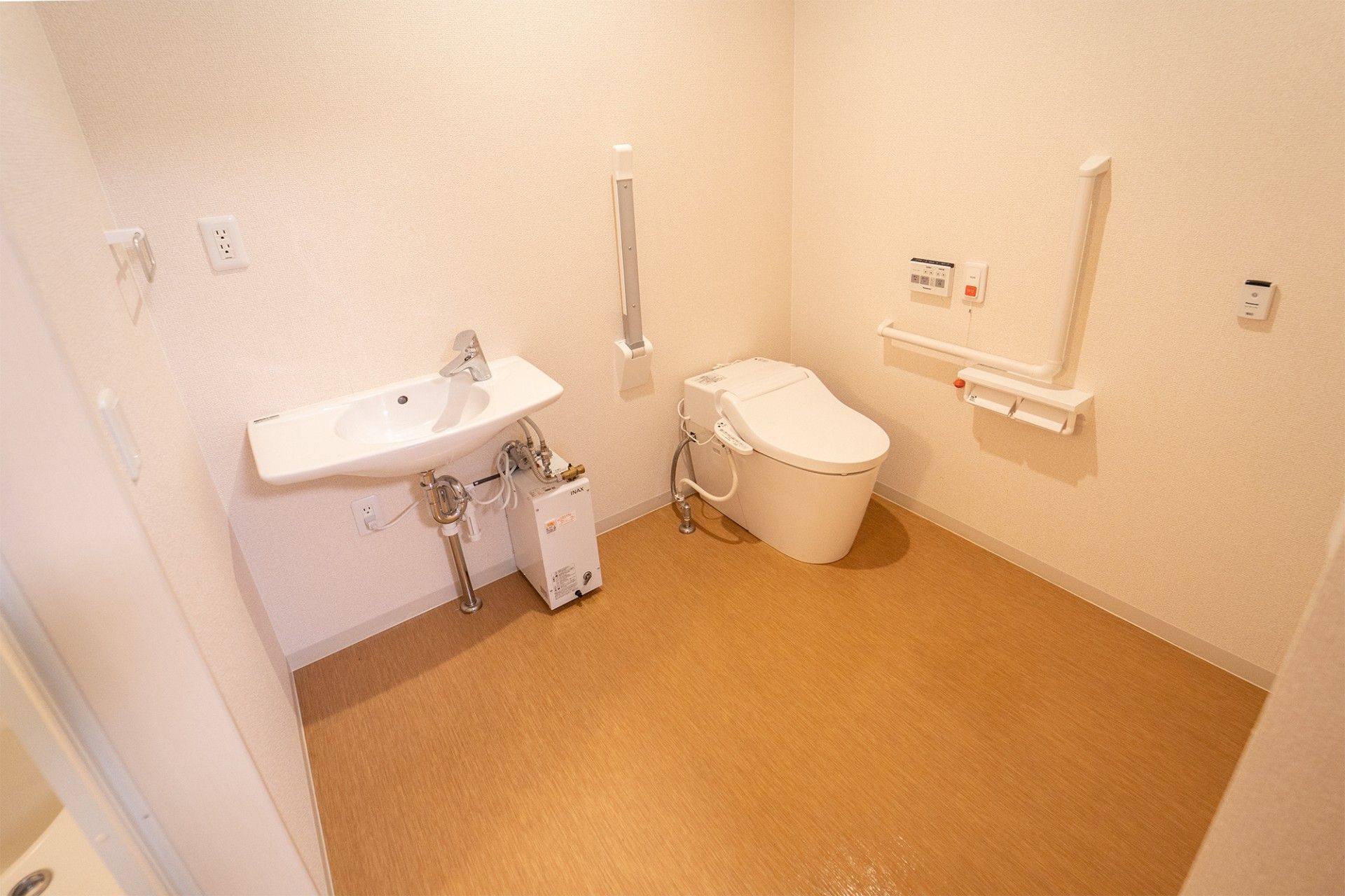 居室のトイレは必要最低限のものしか置かれておらず、すっきりしており転倒の危険性も少なくなっている。手すりが２ヵ所に用意されている。