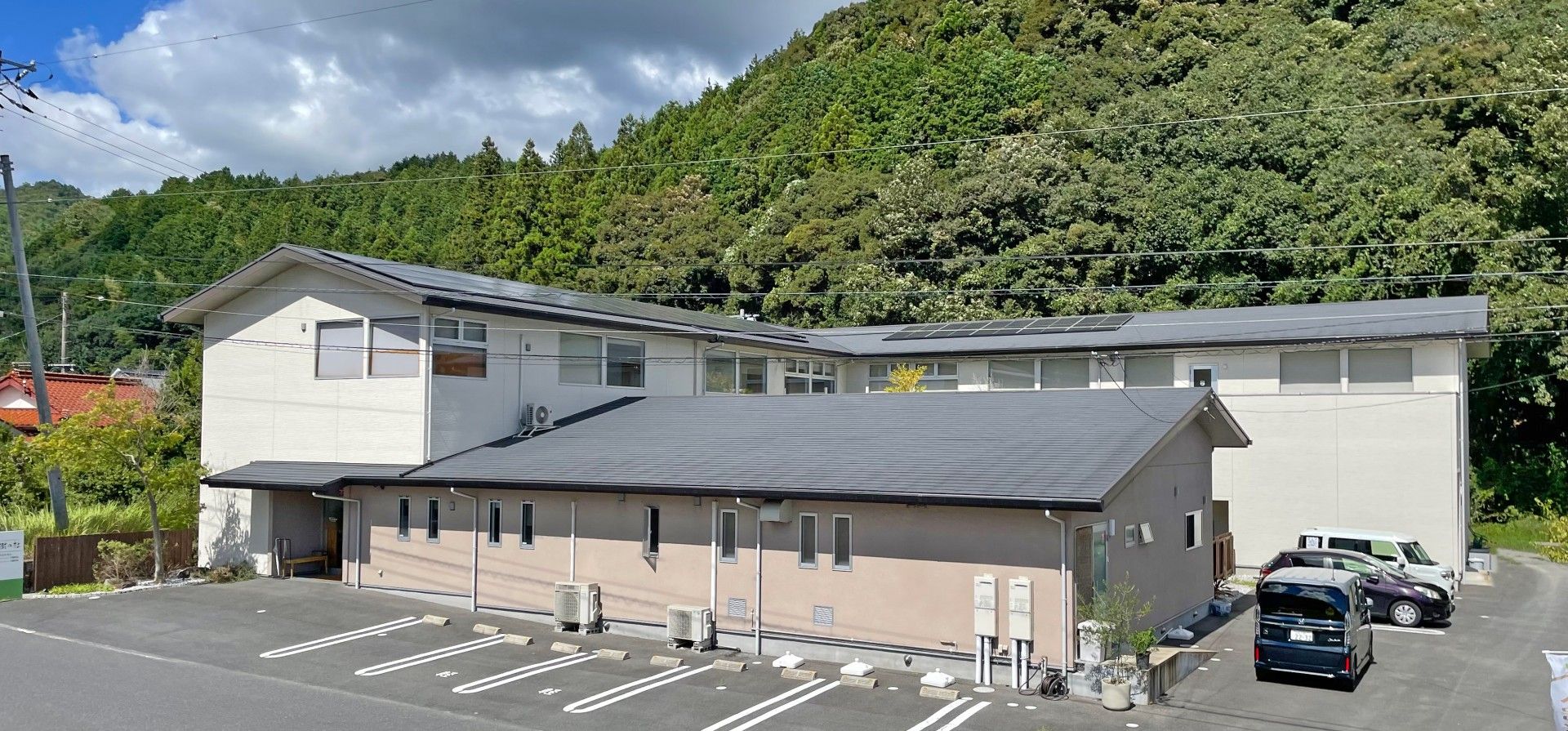 茶色い色とアイボリーで色分けされた壁の建物。屋根は黒で統一されている