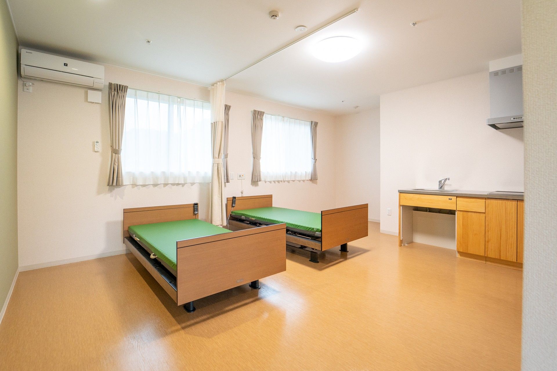 緑色のマットレスが載せられたベッド2台が置いてある部屋