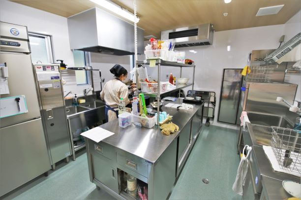 木の模様が印象的な床。梁が見えるモダンなデザインの天井が見えている