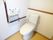 エル字型の手すりが設置されたトイレには呼び出しボタンやトイレットペーパーホルダーも付いている。