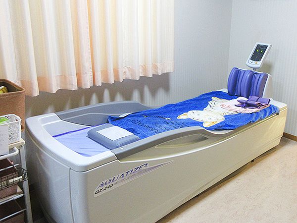 猫のイラストが描かれた大きなタオルがかけられているウォーターベッドが置かれている。