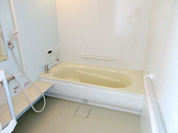一人用の浴槽が設置された浴室にはたくさんの手すりが付き、呼び出しボタンも付いている。