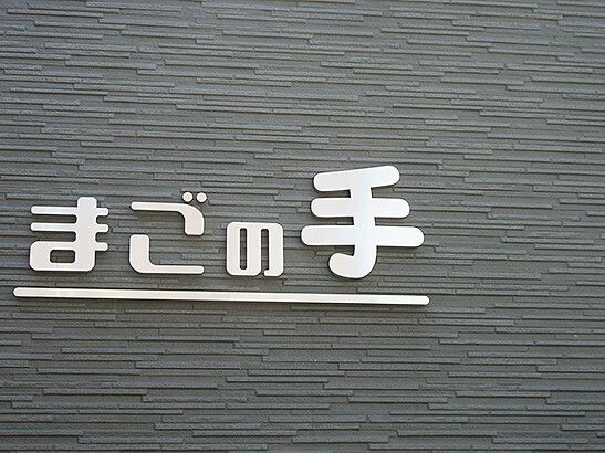住宅名がシルバーの文字で書かれたダークグレーの外壁。汚れもなく、特に他には書かれていない。