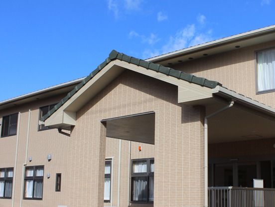 ２階建ての建物。ブラウンを基調とし、出入り口には屋根が付いている。