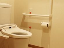 トイレは白でまとめられていて、壁には手すりや呼び出しボタンが付いている。
