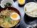 卵や野菜が乗ったラーメンと白いご飯、青菜の和え物にデザートが添えられている。