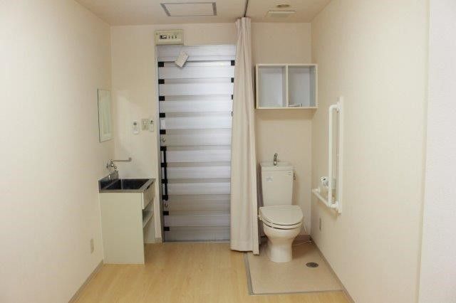 居室にあるトイレは、立ち上がりが楽に行えるように、手すりを取り付けている。収納棚も設置しているので、すっきりとした空間を維持できる。
