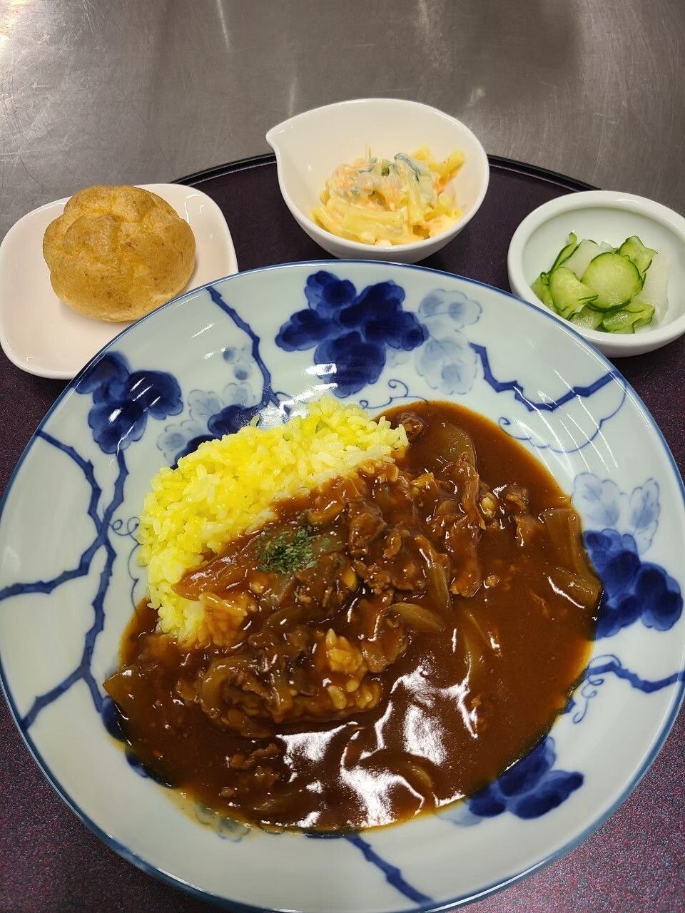 丼にハッシュドビーフがあり、こばちにきゅうりなどがある